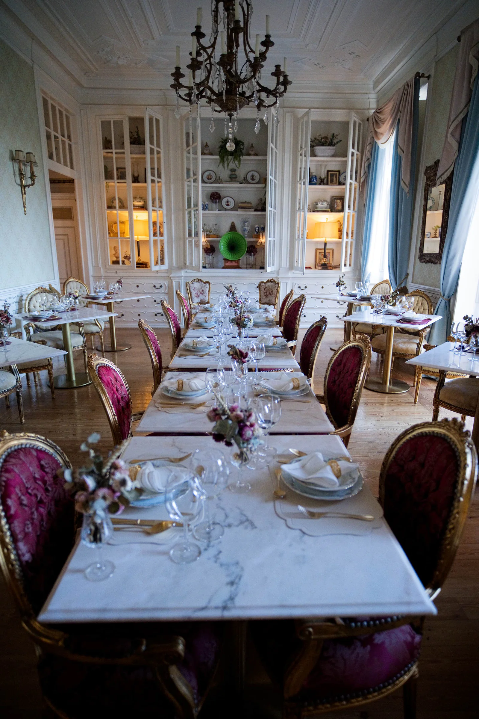 Opulent dining room set for the reception with gold chairs and crystal glassware