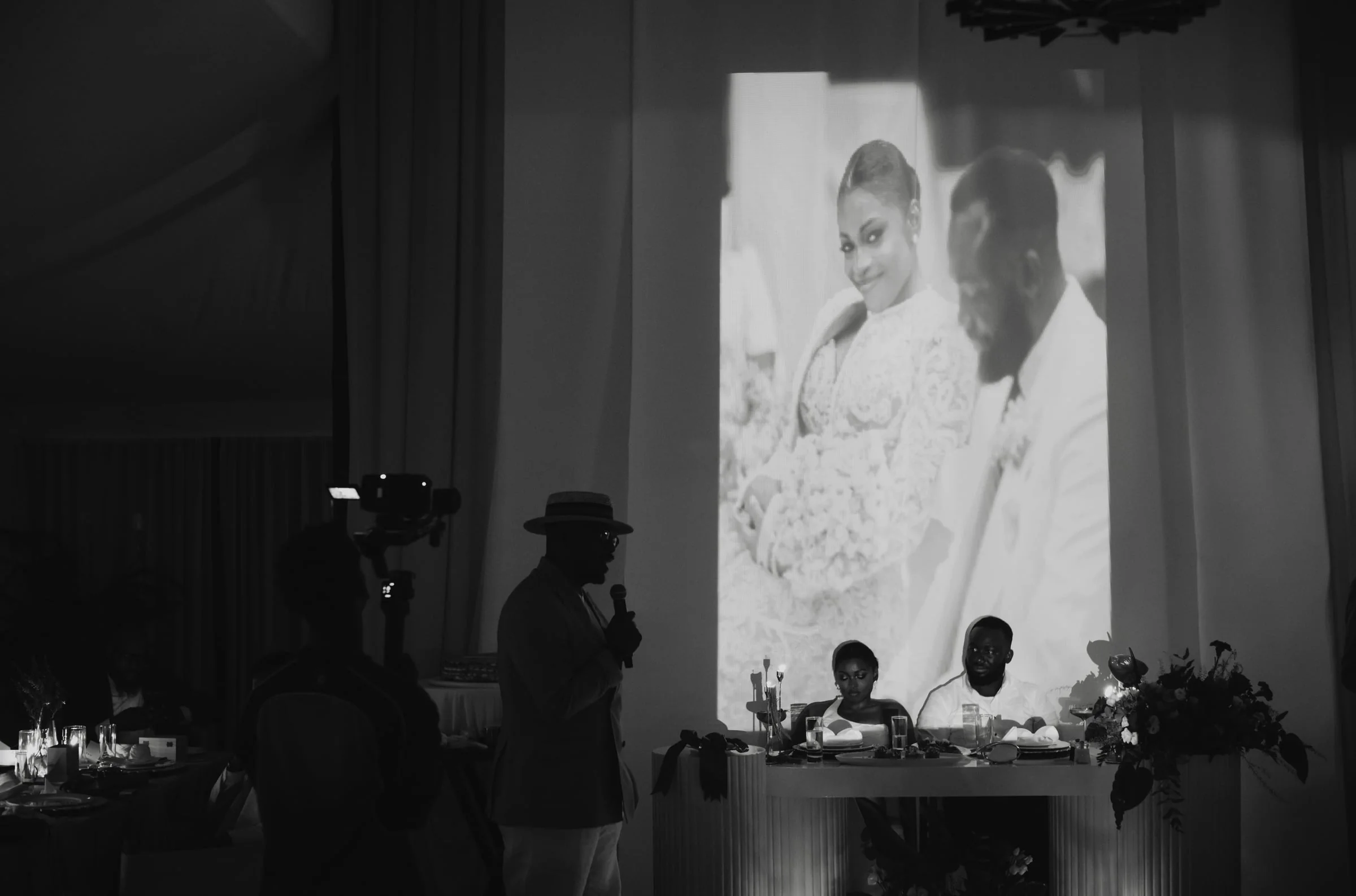 Guests toasting the couple as their photo is projected on screen behind them